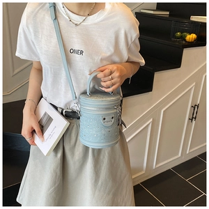 Détail montrant les strass haute densité sur un sac seau bleu clair avec garniture argent