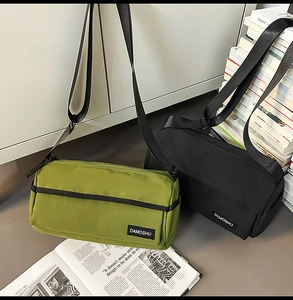 Détail de sacs bandoulière cylindriques tendance en vert et noir avec sangle