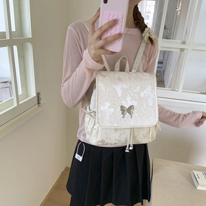 Detail of white butterfly embossed backpack with a silver butterfly shaped metal buckle