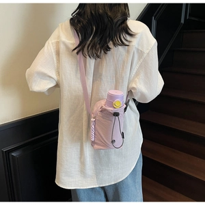 Détail du sac à téléphone en toile imperméable violette avec bandoulière sur mannequin