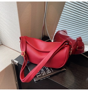Detail of red lychee grain leather hobo bag with adjustable strap and golden hardware