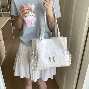 Close-up of white tote bag with butterfly embroidery and satin ribbon drawstring