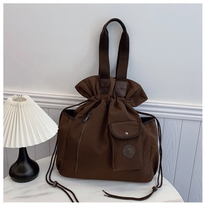 Detail of dark coffee canvas bucket bag with drawstring closure and front pocket