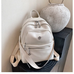 Detail of off-white PU leather backpack with geometric strap and gold-tone zippers
