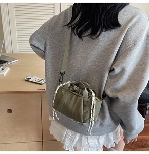 Olive green bucket bag with drawstring detail and adjustable strap shown on model