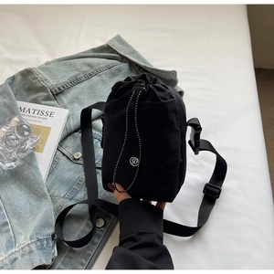 Détail du sac bandoulière noir en nylon à cordon avec logo D brodé et sangle ajustable