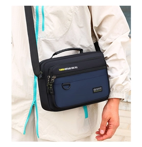 Macro shot of a waterproof nylon crossbody bag with zipper compartments and carry handle