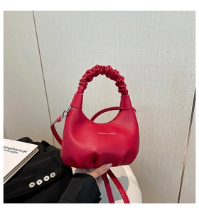 Détail du sac hobo en cuir rouge avec poignée froncée et fermeture éclair élégante