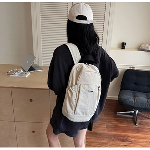 Rear view of a stylish off-white nylon backpack with adjustable straps and logo detail