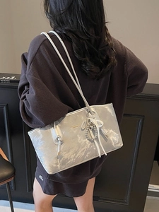 Borsa tote argento metallizzato con trama marmorea e ciondolo a cuore indossata a spalla