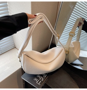Detail of white crescent bag with lychee texture leather and adjustable shoulder strap