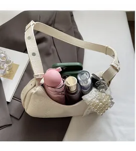 Detail of cream pleated leather shoulder bag showing large capacity for essentials