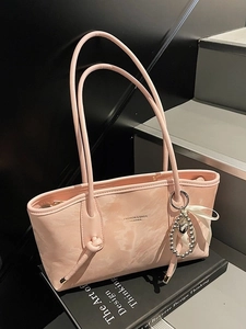 Borsa tote in ecopelle rosa chiaro con spalline sottili e ciondolo a cuore su sfondo sobrio