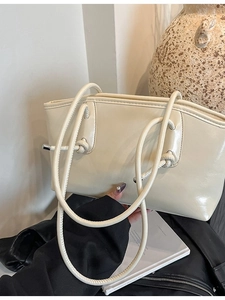Sac bandoulière crème minimaliste avec poignées nouées et finition en cuir lisse