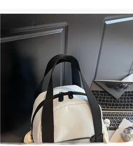 Close-up of minimalist beige backpack with durable black woven handles and double metal zippers