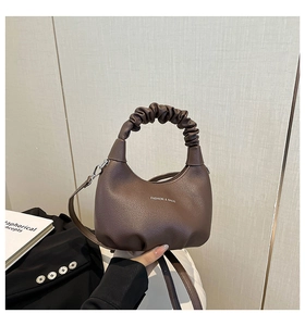Vue détaillée du logo sur le sac croissant marron avec une poignée à effet froncé