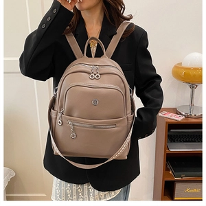 Detail of dark khaki leather backpack with lychee texture and multi-pocket design