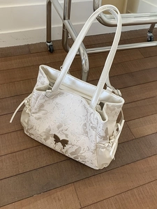 Cream tote bag with floral butterfly print and elegant gold buckle detail