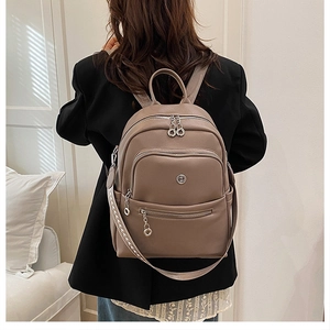 Detail of tan PU leather backpack with荔枝 texture and stylish geometric woven strap