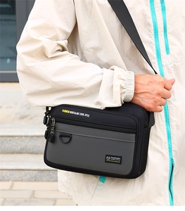 Close-up of casual men's oxford crossbody bag with yellow text on shoulder strap