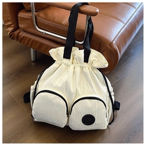 Detail of off-white nylon drawstring backpack with two front zipper pockets and logo