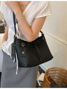 Chic black woven shoulder bag with letter M charm and adjustable silver buckle strap