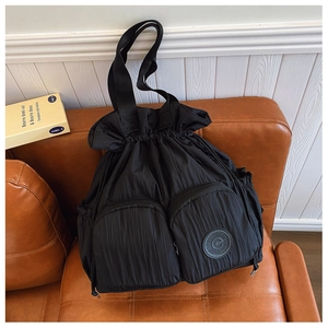 Detail of black waterproof nylon backpack with drawstring and dual front zipper pockets