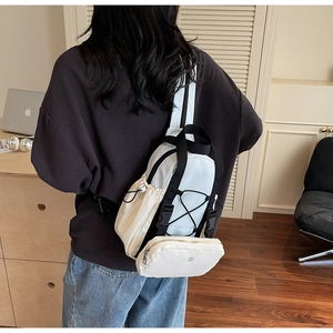 Close-up of functional cream and blue chest bag with multiple pockets and a small round pouch