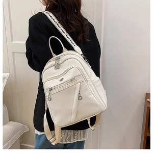 Zaino bianco in ecopelle con tracolla geometrica e cerniere argentate indossato da modella