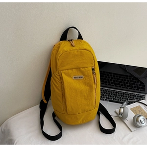 Detail of yellow casual backpack with front zipper pocket and adjustable black straps