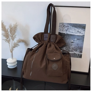 Detail view of large canvas travel tote with drawstring closure and front pockets
