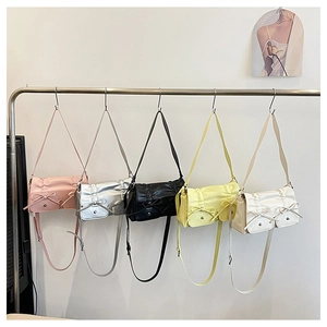 Detail view of five PU leather crossbody bags with bows in pink, silver, black, and yellow