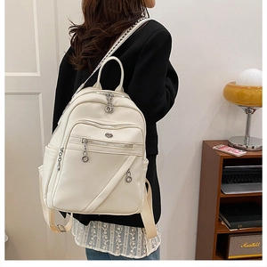 Dettaglio dello zaino color crema in pelle sintetica con spallacci intrecciati e metallo argento