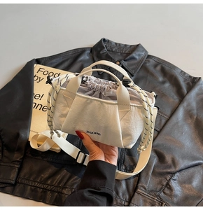 Close-up of cream canvas bucket bag with drawstring closure and brand logo
