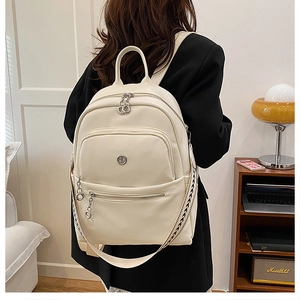 Detail view of cream leather backpack with lychee texture and woven checkerboard strap