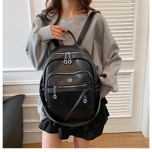 Dettaglio di uno zaino classico in pelle nera con tasche multiple e finiture in argento