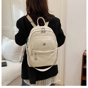 Detail of cream leather backpack with multi-layer zippers and woven strap trim