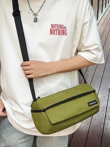 Sac bandoulière cylindrique en toile verte avec sangle noire et design minimaliste
