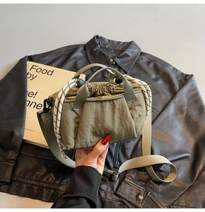 Detail of army green nylon bucket bag featuring drawstring closure and textured fabric
