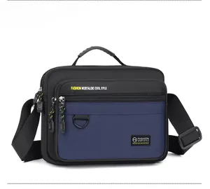 Detail view of Oxford fabric shoulder bag with multiple zippered pockets and top handle