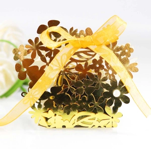 Close-up of golden laser-cut floral favor box with yellow organza ribbon and bow