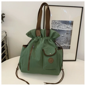 Detailed close-up of retro green canvas bucket bag with drawstring and front pockets