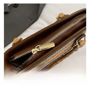 Close-up of golden zipper hardware and woven colorful fabric on stylish bucket bag