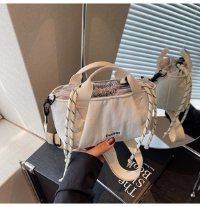 Detail shot of the drawstring closure and white fabric texture on the bucket bag