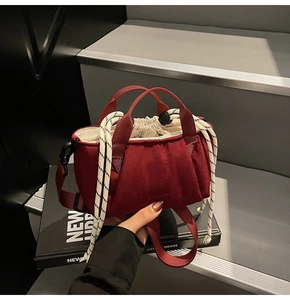 Detail of red drawstring bucket bag showing velvet texture and woven rope handle