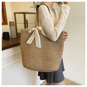 Close-up of woven straw tote bag with elegant white lace bow and brown handles