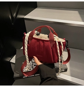 Close-up of a deep red drawstring bucket bag with ZHUOFAN logo and woven handles
