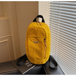 Close-up of bright yellow nylon backpack with a vertical zipper and YOU JI BEAR logo