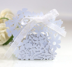 Close-up of light blue laser-cut flower hollow gift box with white silk ribbon bow