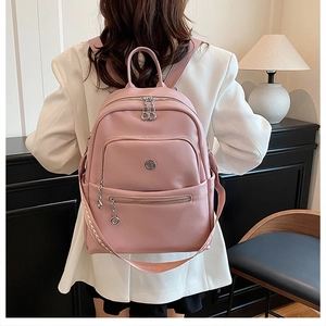 Pink PU leather backpack with geometric strap shown on model in a modern indoor setting